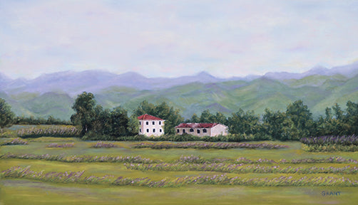 Tuscany is a pastel painting by joanne grant.  It is a landscape of a scene in tuscany italy.  There are purple mountains set against a pink and blue soft sky.  In front of the purple mountains are green mountains.  A mediterranean style white house with a red clay roof sits in the middle of the painting.  Surrounding the house are trees and in the foreground is a green/yellow grassy field.  The colors are soft and muted.